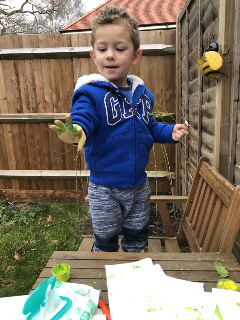 Messy play - painting oak leaves in the garden