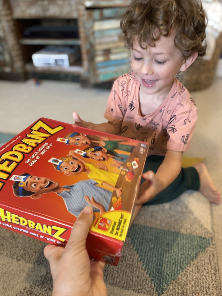 A boy is getting the Hedbanz Game from spinmaster