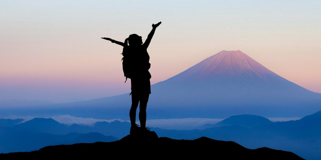 Woman on the top of a mountain with her arms outstretched