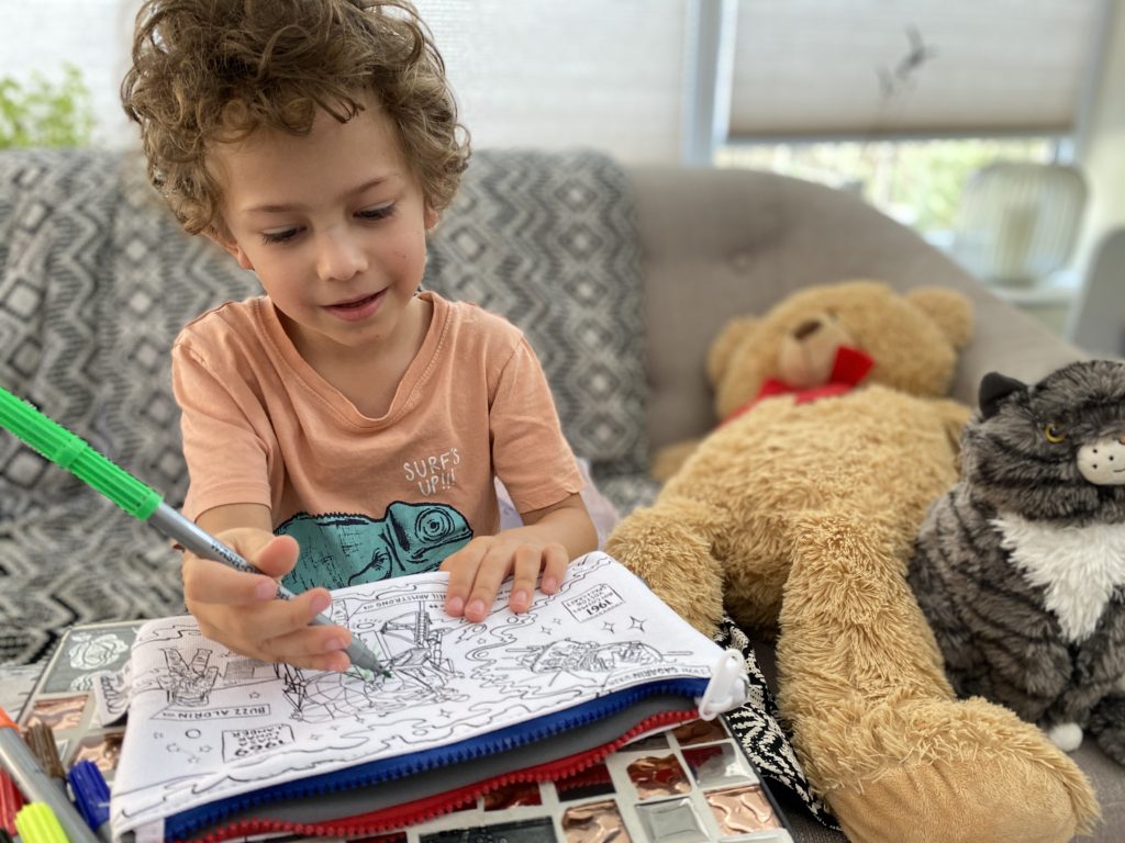 Young boy colouring in his space pencil case from eat sleep doodle
