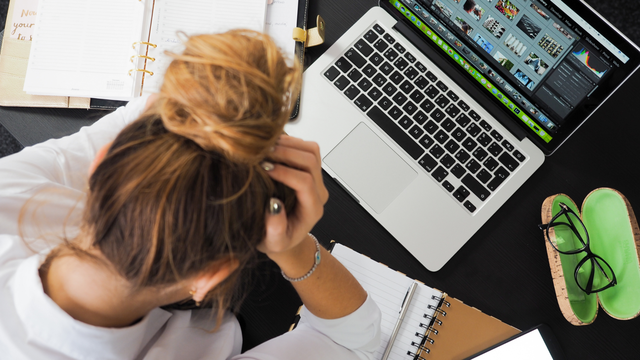 Stressed woman head in hands by laptop