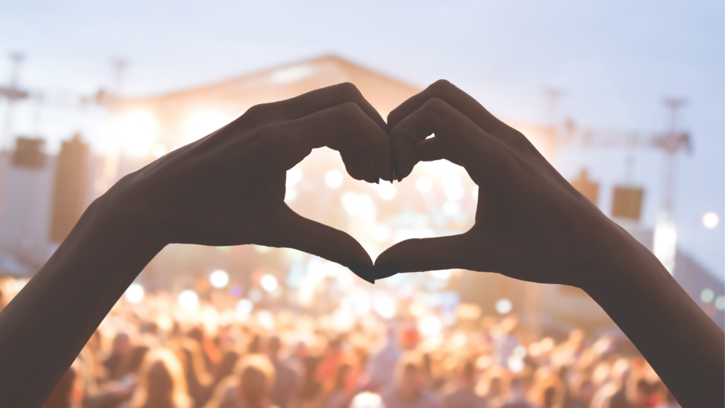 Hand making a heart at a concert