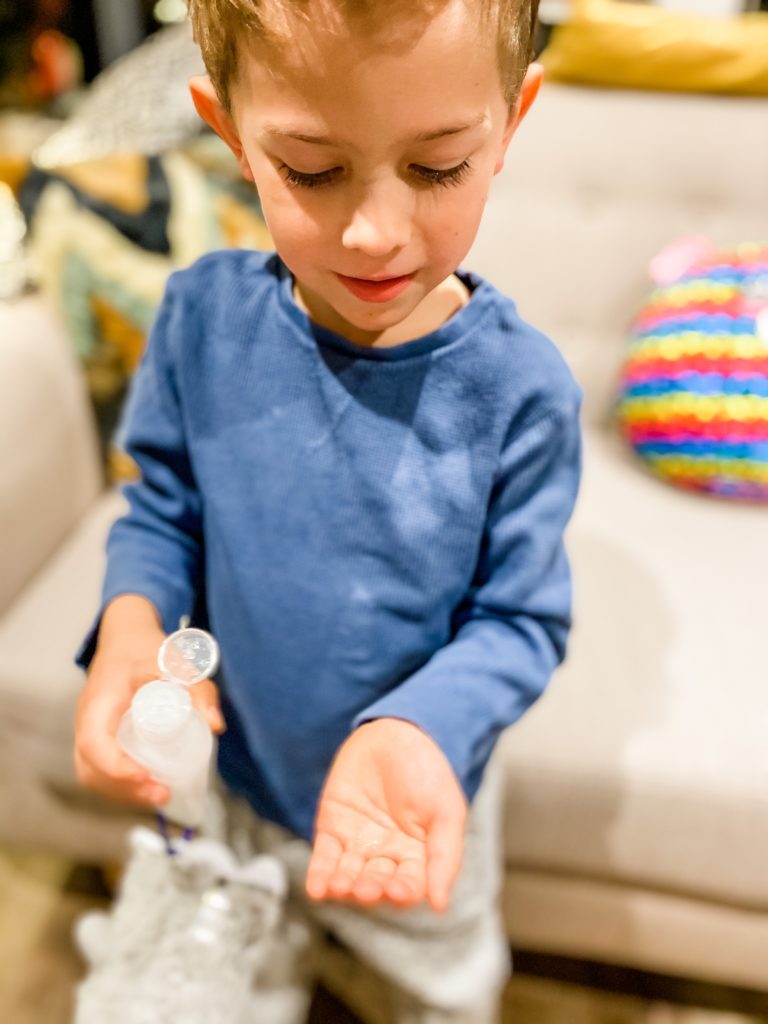 Young boy using hand sanitiser