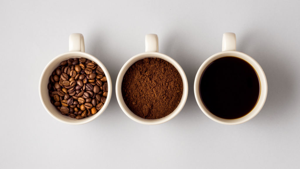 Coffe mugs one with coffee beans one with ground coffee and one with liquid coffee