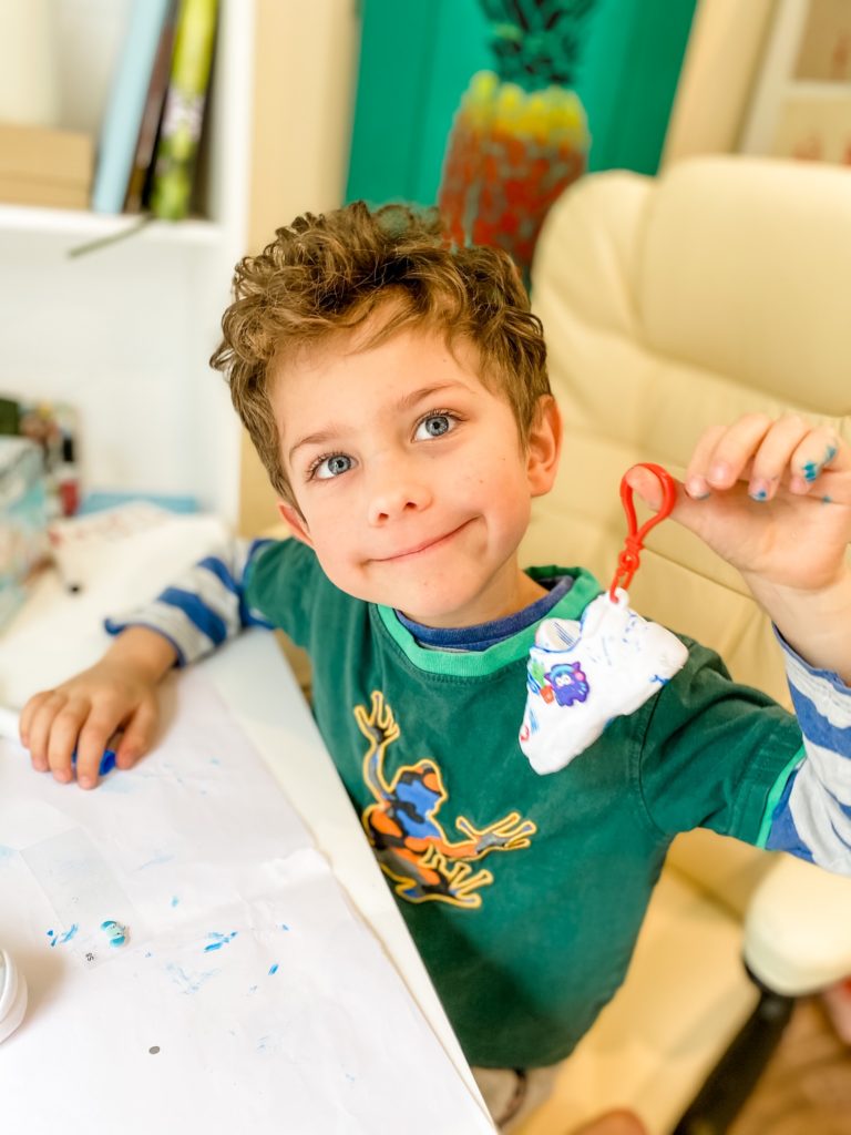 Boy holding the keychain on the sneaker of Sneak Artz