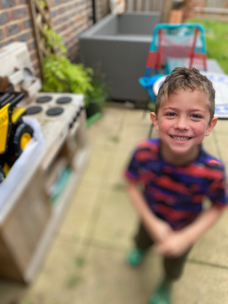 Happy boy enjoying toys in the garden