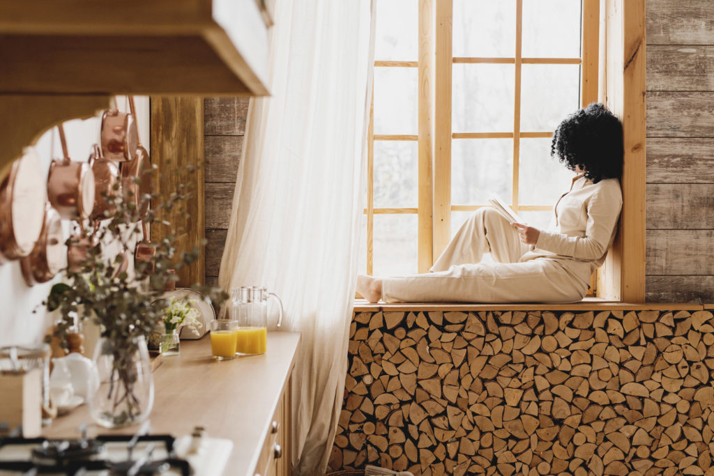 Lady sitting on windowsill reading a self-help book