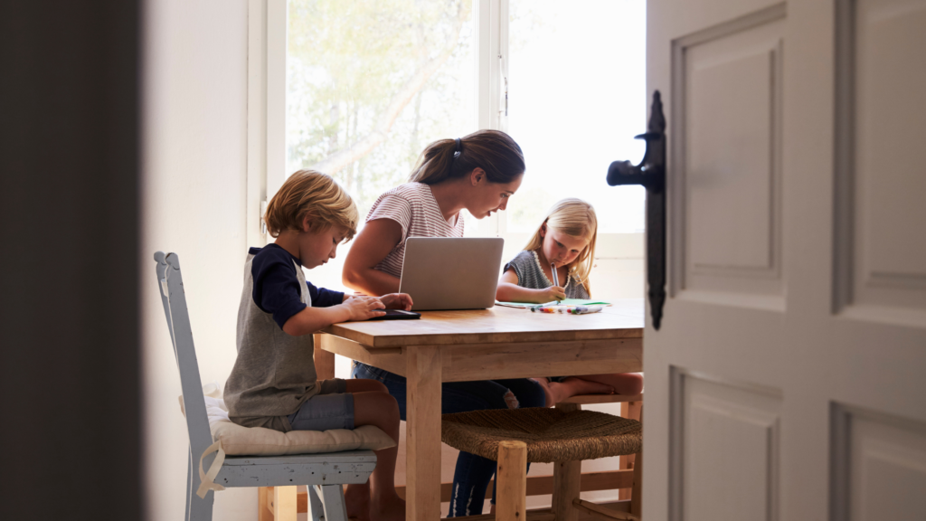 Working foster care mum life with mum at the table with her laptop and 2 kids