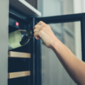 Lady's arm reaching to put a bottle of white wine in the wine cooler