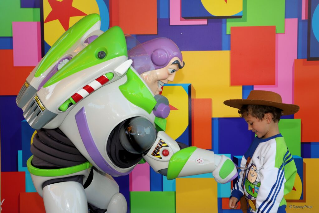 Buzz lightyear at Disneyland Paris with boy wearing Toy story top