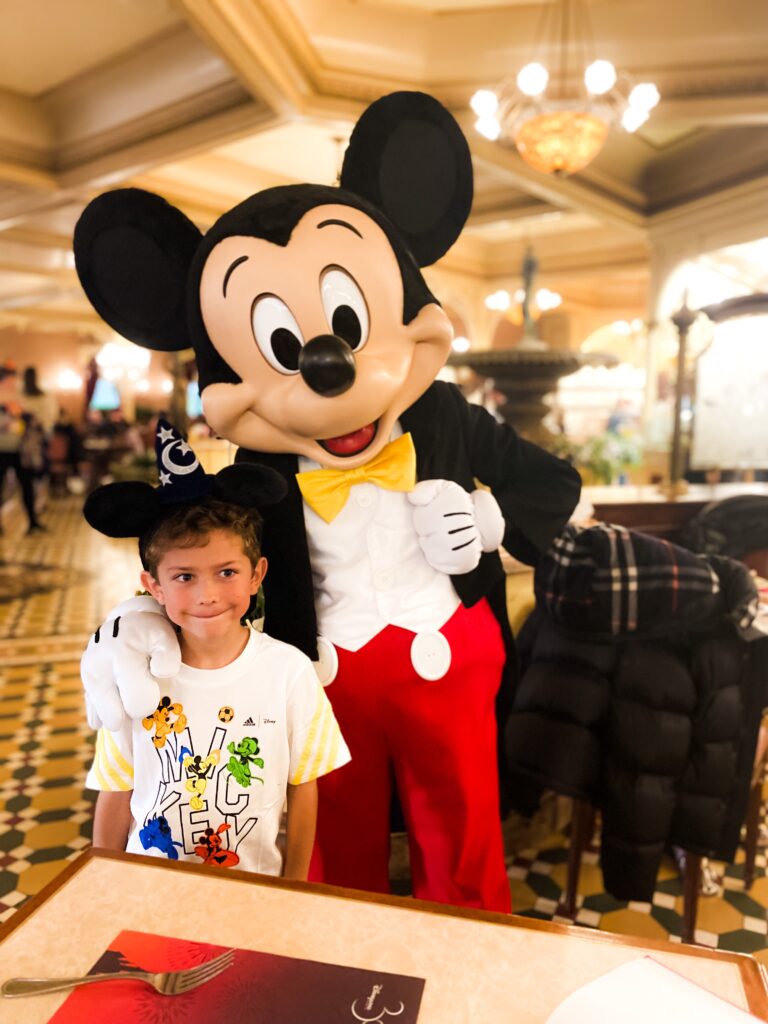 Boy meeting Mickey Mouse at Plaza Gardens Restaurant at Disneyland Paris