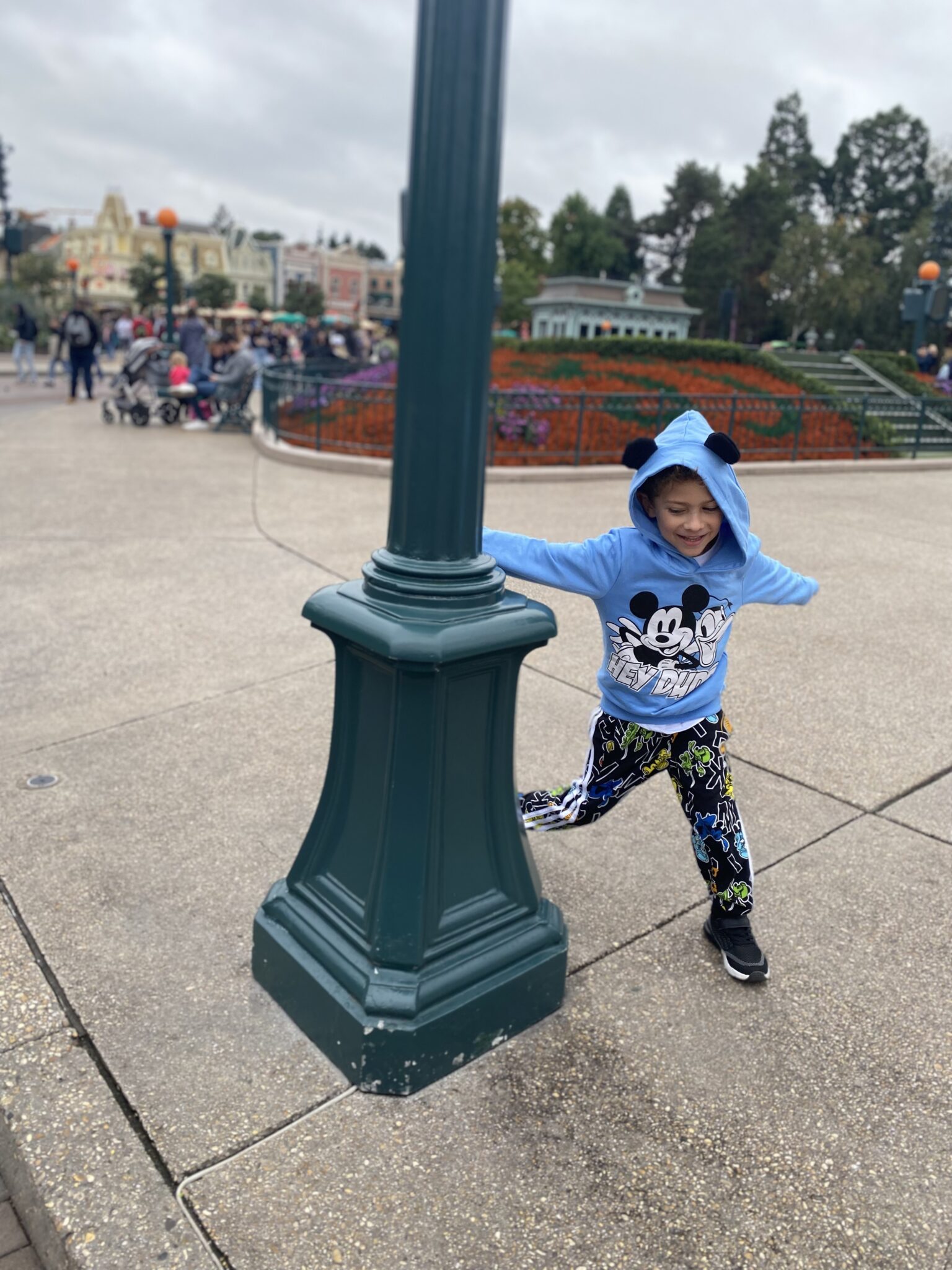 Boy running round a lampost at Disneyland Paris