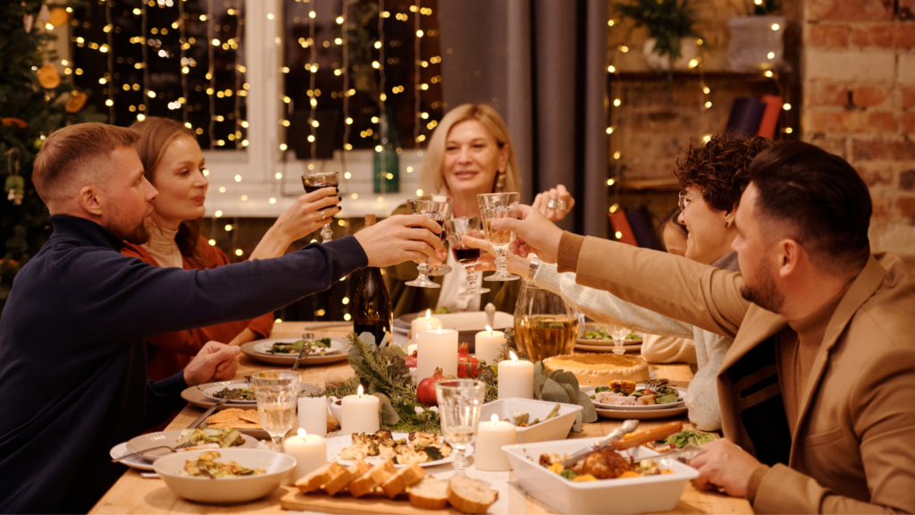 Friends round a table toasting at a Christmas dinner party