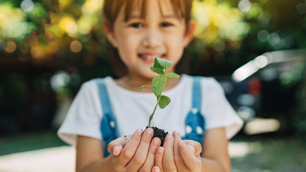 Girl holding up plant she's grown