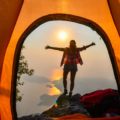 View of woman from a tent enjoying the incredible view on a backpacking adventure