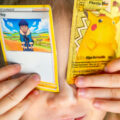 Kid with pokemon trading cards covering her eyes