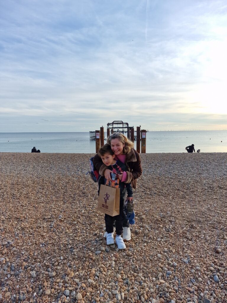 Mum and son by the west pier with their Brighton artist-anon bag