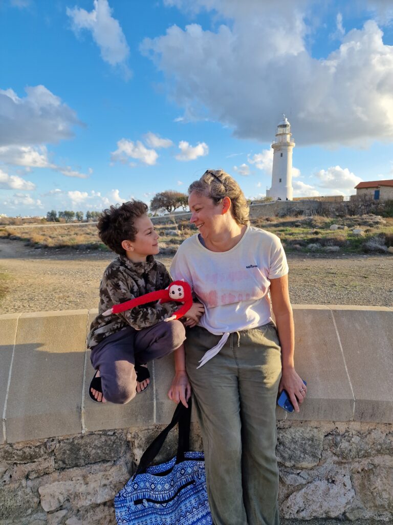 Mum and son at Kato Paphos Archaeological Park with lighthouse in background