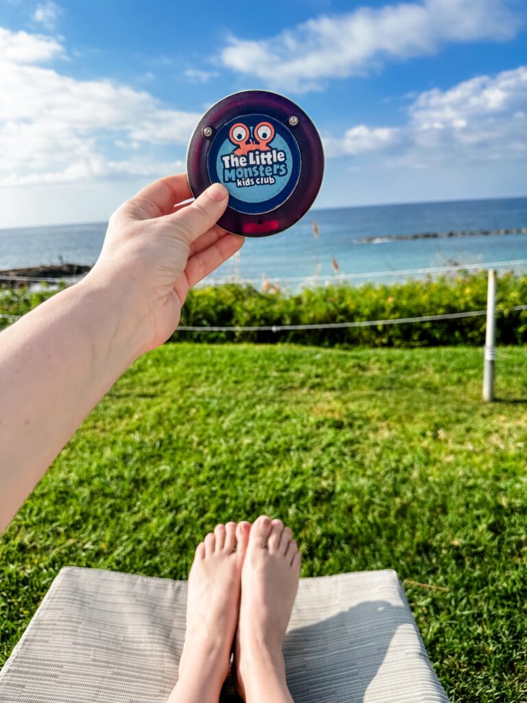 Kids club buzzer at Alexander the great beach hotel whilst mum relaxing on hotel sun lounger looking out to sea