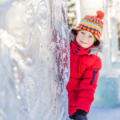 Child peering from behing giant ice