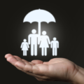 A hand holding cartoon family in white with umbrella
