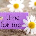 Time for me written on a purple card on a woodewn table with daisies around it to encourage me time