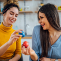 Two ladies who are best friends at Easter comparing eggs