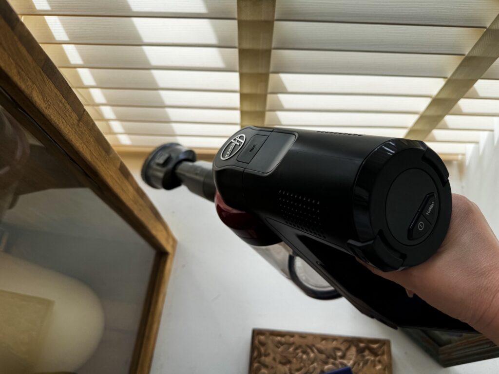 Hoover cordless vacuum with upholstery attachment cleaning bay window and blinds