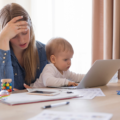 Stressed mum trying to work at home with her baby on her lap