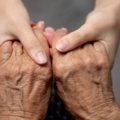 Someone holding an elderly person's hand