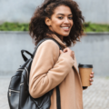 Working mum on the way to the office with a coffee and her work packpack
