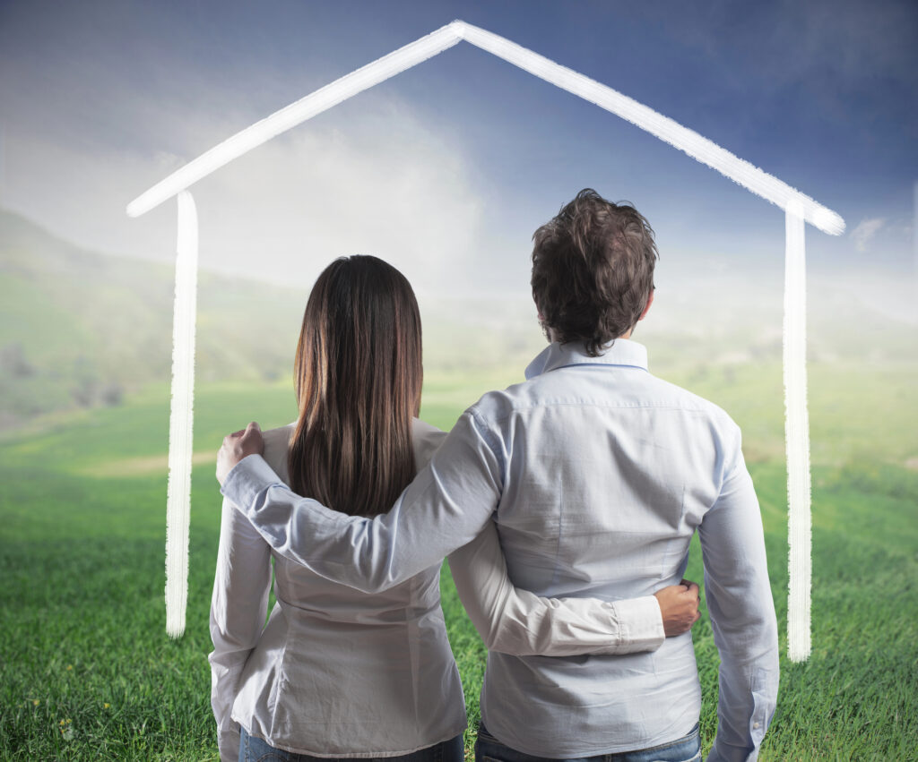 A couple looking at a field with a imiginary house is drawn out with a white line