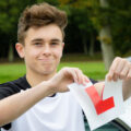 Boy who has just passed his driving test ripping his L plate in half
