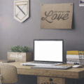 A desk in a home office with a picture above the desk saying Love