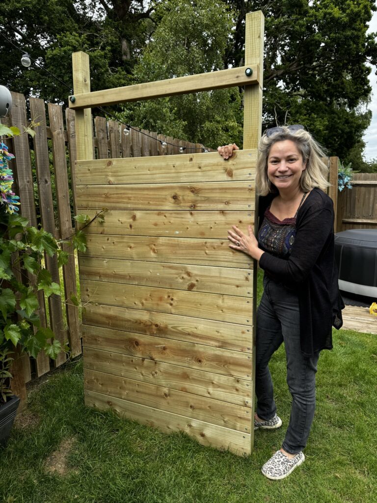 Mum holding up a side panel of the Wickey Climbing Tower