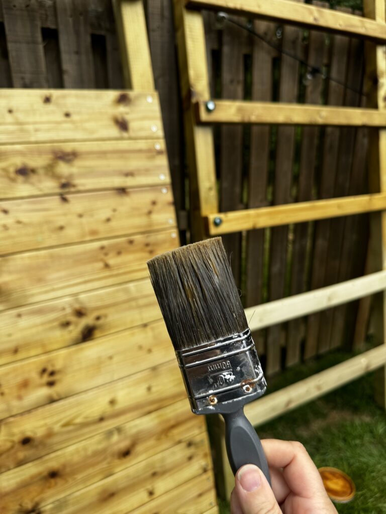 Paint brush by the wood panelling of the Wickey Climbing Tower