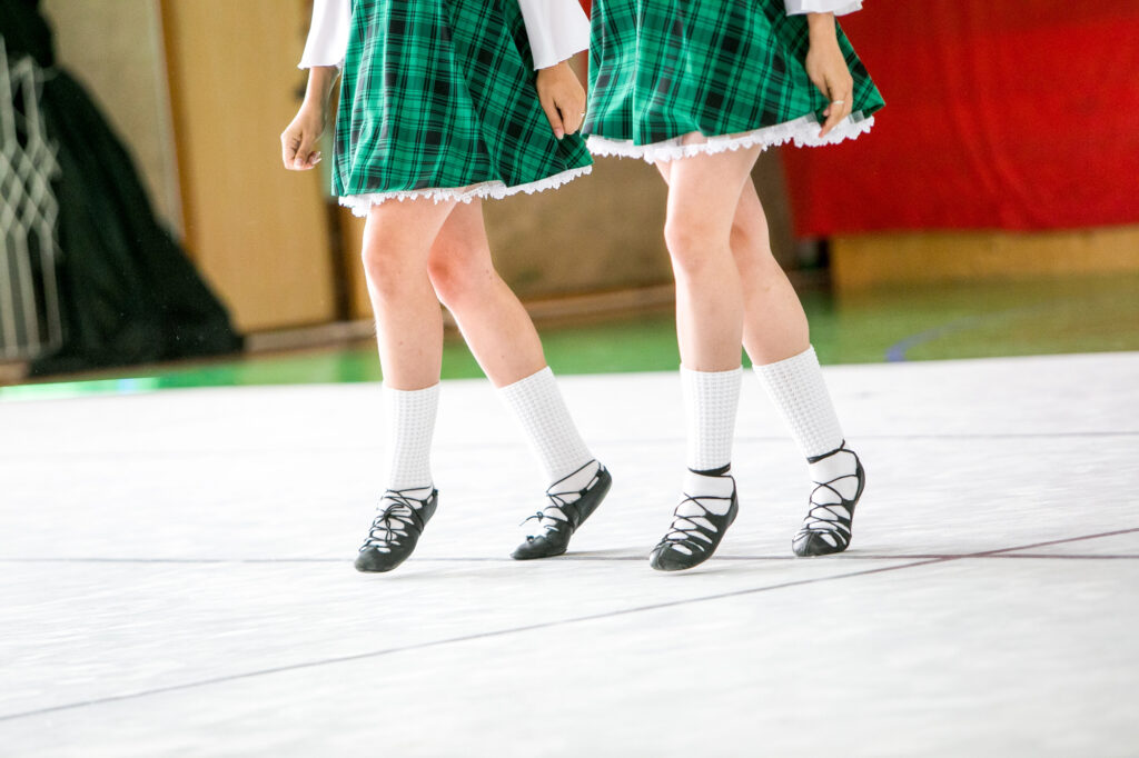 Two girls legs in green skirts Irish Dancing