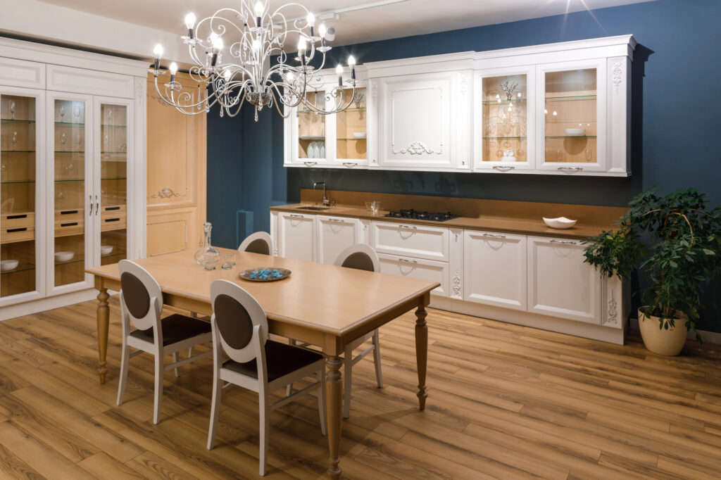A kitchen with a table and chairs under a chandelier