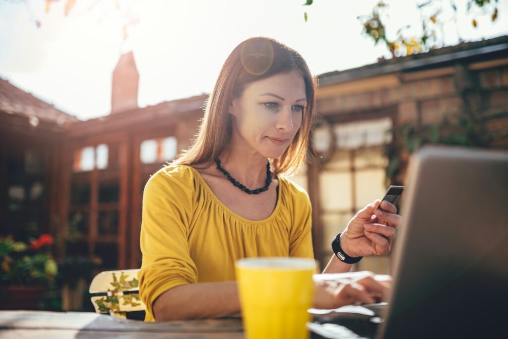 Working mum on holiday taking time to check her work emails whilst enjoying the beautiful outdoors and a glass of orange juice