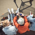 teenagers hanging out in a car park with the shadow of a shopping trolley