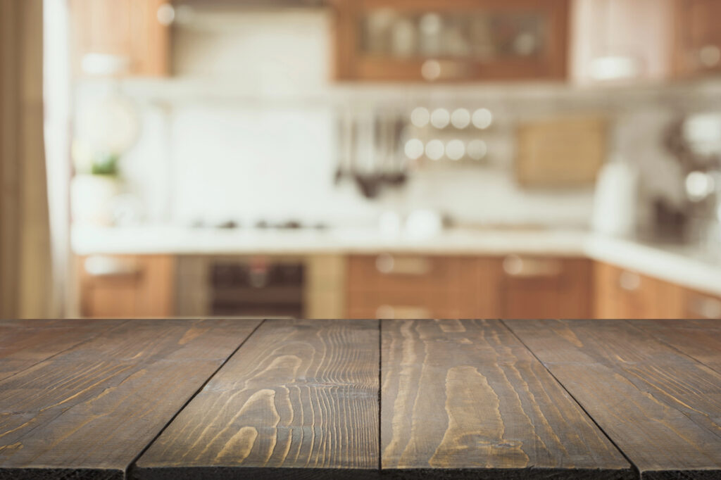 Blurred background of modern kitchen taken from wooden counter top