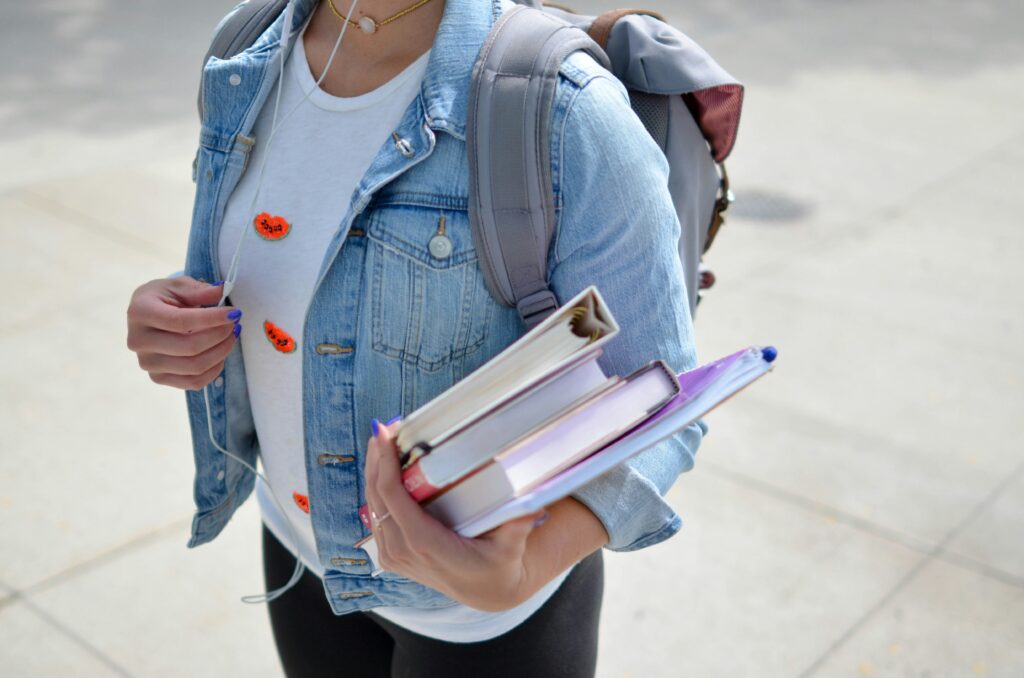 Girl ready for university with books and rucksack