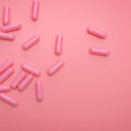 Pink supplements spilling out onto a pink background