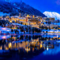 View of beautiful night lights of St. Moritz in Switzerland at night, with reflection from the lake and snow mountains in backgrouind