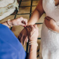 mum helps the bride to fasten jewellery on her hand, close up