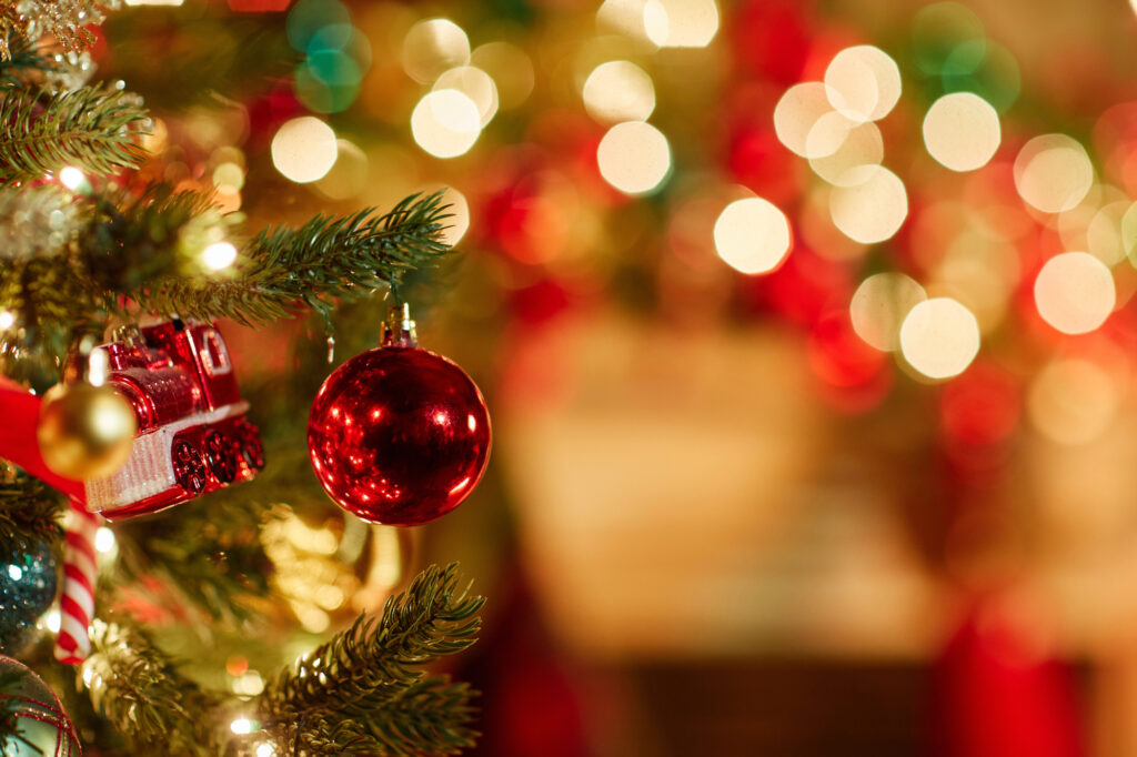 Close up background image of single red ornament on Christmas tree
