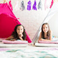 Two girls having a pyjama party with teepees to sleep in.