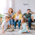 Big family watching TV together at home in their living room