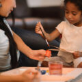 Little car learning to paint with her mum