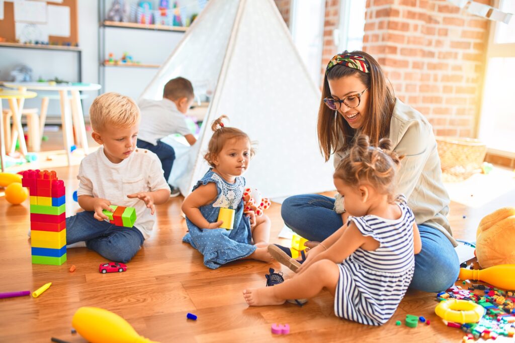 Young children with pre-school teacher in a nursery